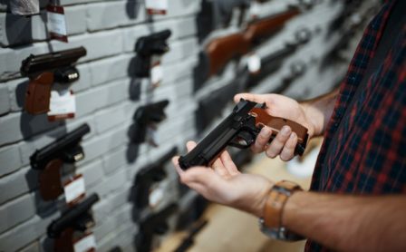 man-holds-handgun-gun-shop-male-person-buying-pistol-security-weapon-store_266732-23562